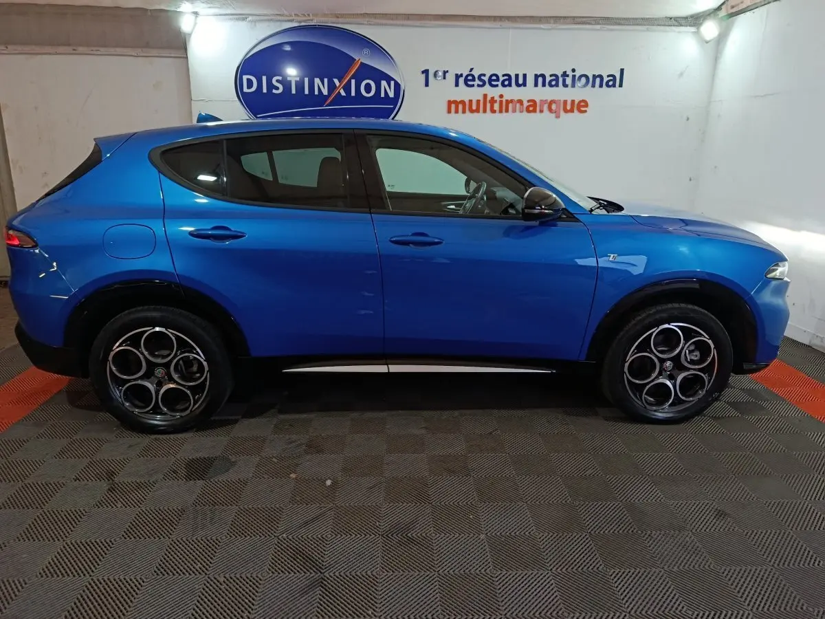 Profil droit d'un Alfa Romeo Tonale bleu 2023 avec jantes distinctives à cinq cercles et détails noirs contrastants.