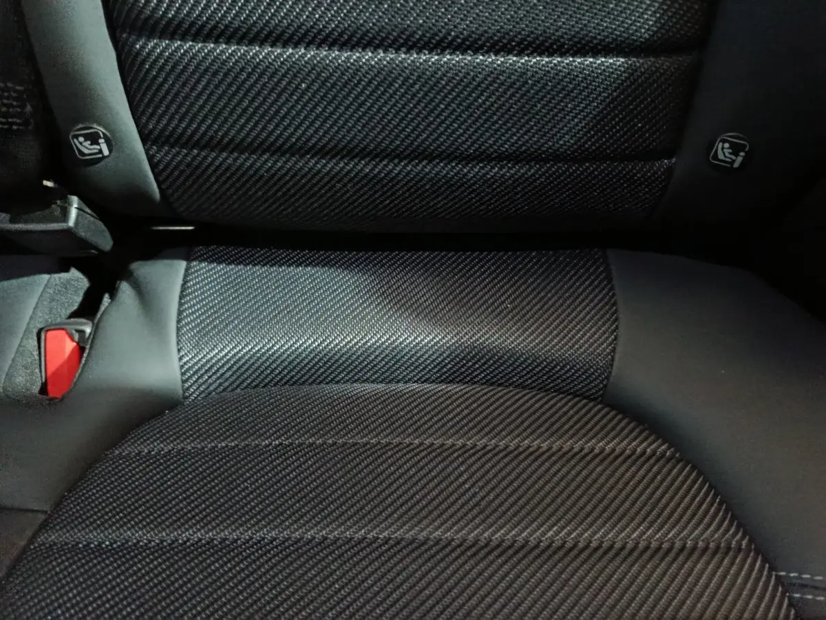 Gros plan sur la banquette arrière noire en tissu texturé de l'Alfa Romeo Tonale hybride rechargeable.