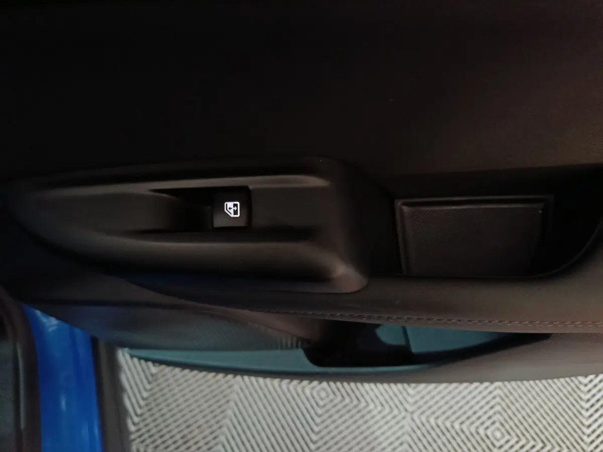 Détail de la commande de lève-vitre sur la porte côté gauche d’une Alfa Romeo Tonale bleu 2023.