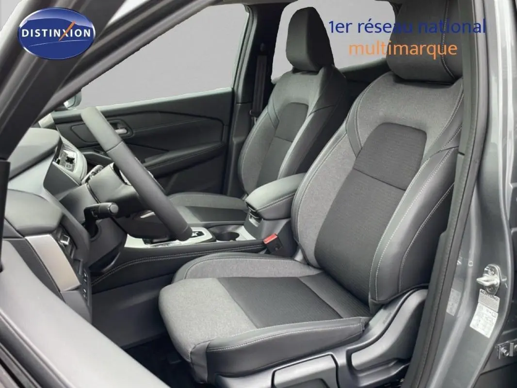 Vue intérieure côté conducteur du Nissan Qashqai gris 2025, mettant en valeur les sièges bi-matière et le volant cuir.