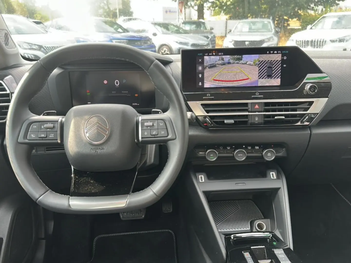 Vue frontale de l'intérieur noir du Citroën C4 X 2025, avec volant cuir et écran tactile affichant la caméra de recul.