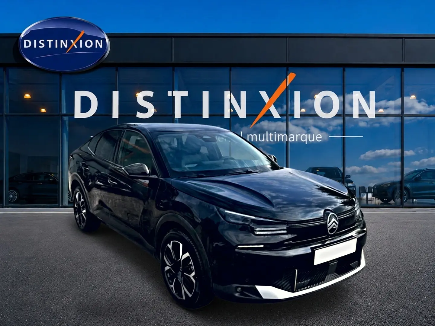 Citroën C4 X noire vue en 3/4 avant droit, avec jantes alu et calandre distinctive devant un showroom Distinxion.