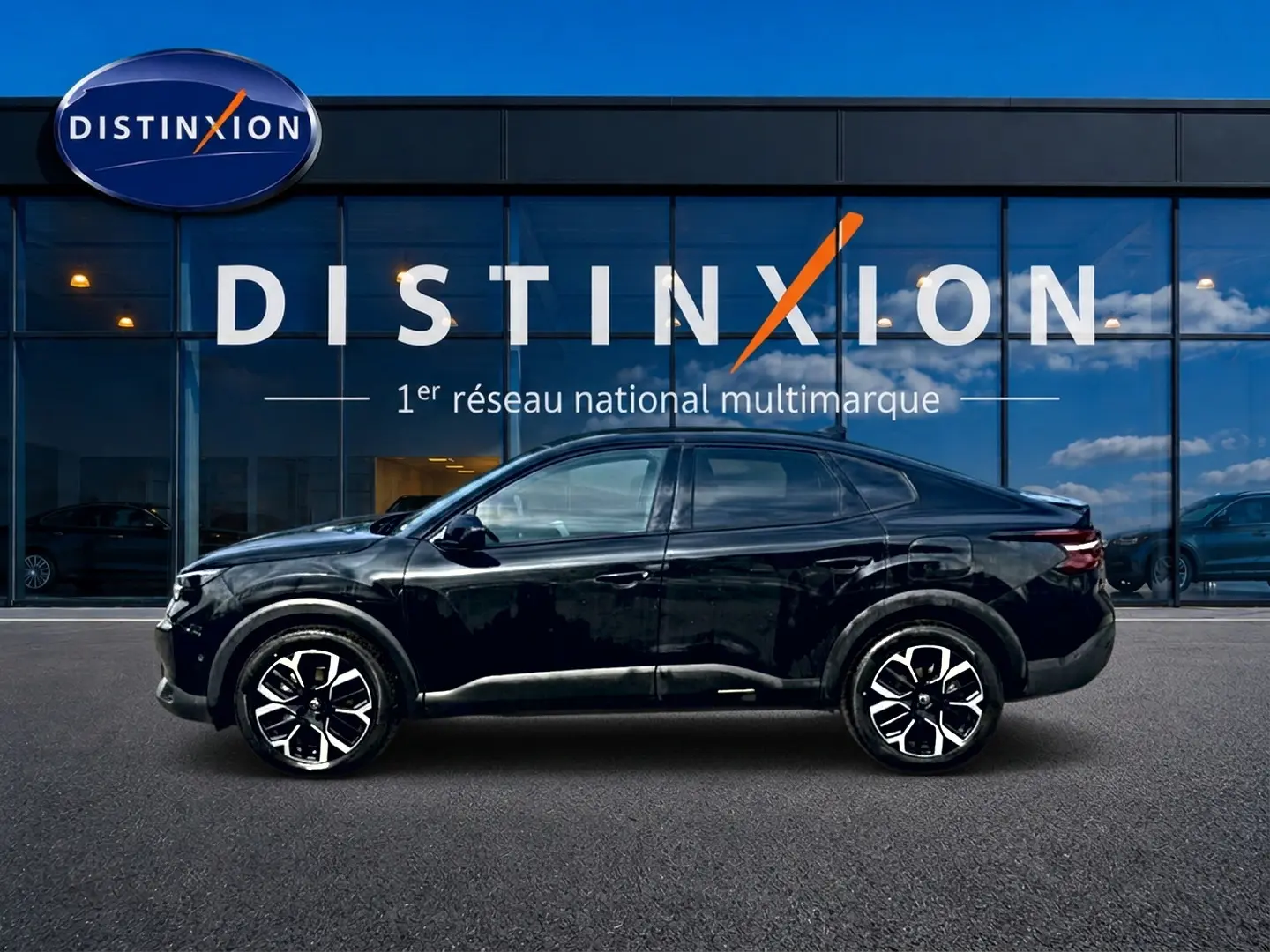 Vue latérale droite d'une Citroën C4 X noire 2025 avec jantes alliage et silhouette élancée devant un showroom Distinxion.