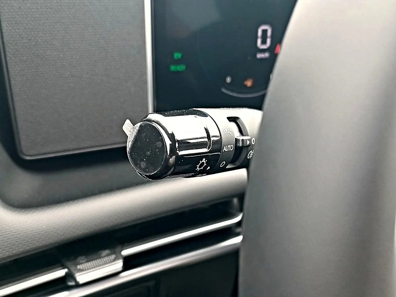Gros plan sur la manette de commande des phares à gauche du volant du Hyundai Tucson gris écotronique 2026.