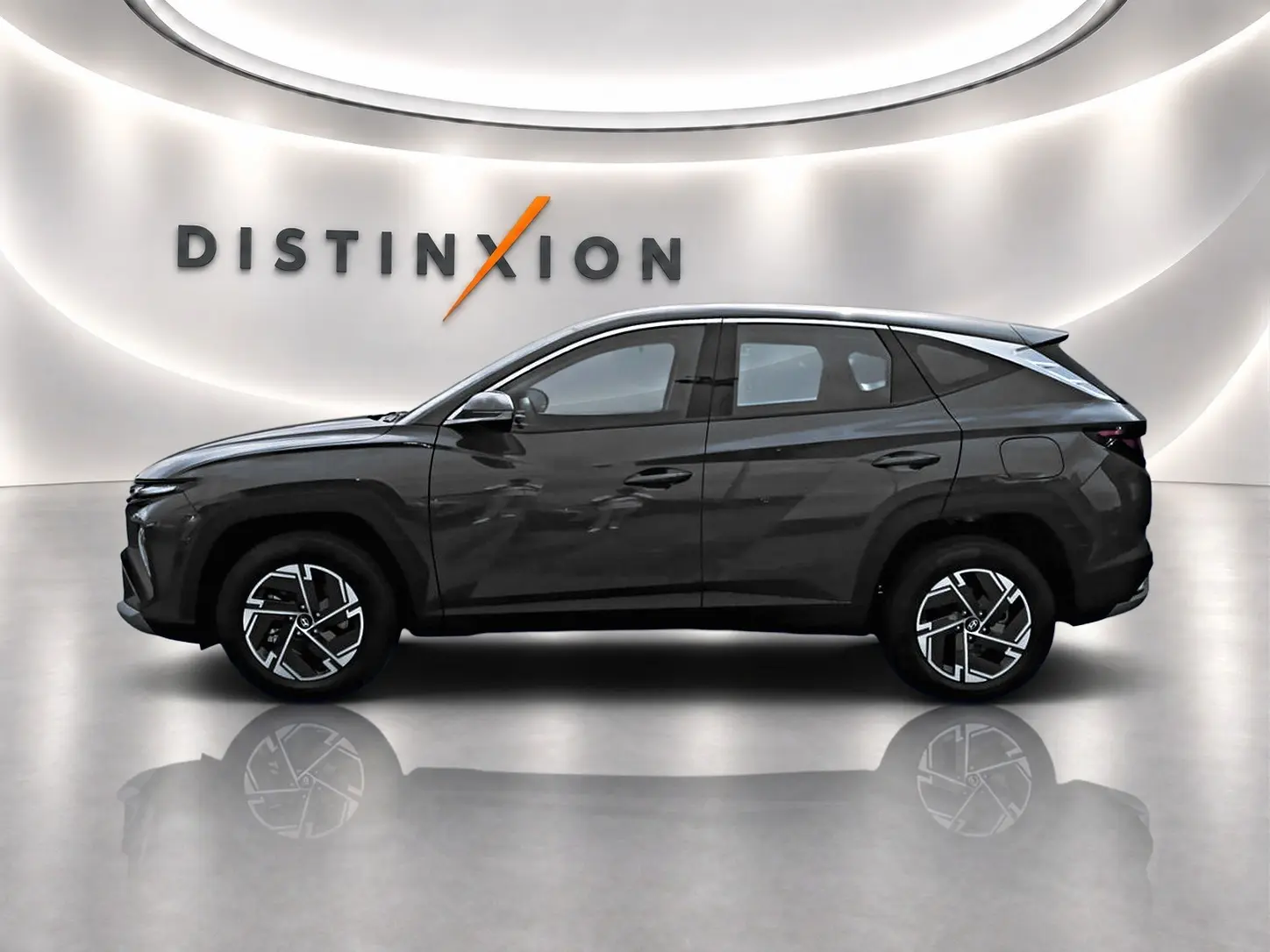 Vue de profil côté gauche du Hyundai Tucson 2026 gris ecotronique avec jantes alliage et rétroviseurs ton carrosserie.