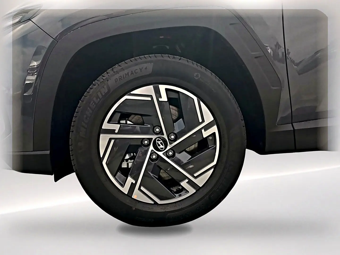 Gros plan sur la roue avant gauche du Hyundai Tucson gris ecotronique avec jante alliage 17 pouces au design moderne.