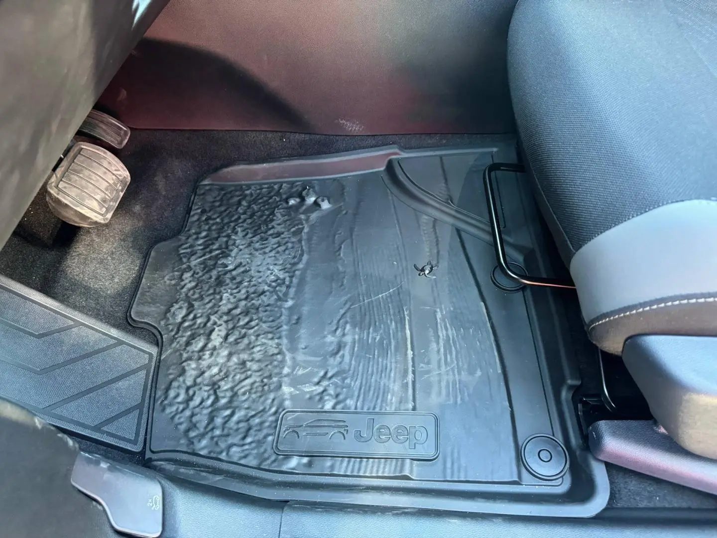 Gros plan sur le tapis de sol noir côté conducteur du Jeep Compass 2026, avec logo Jeep embossé visible.