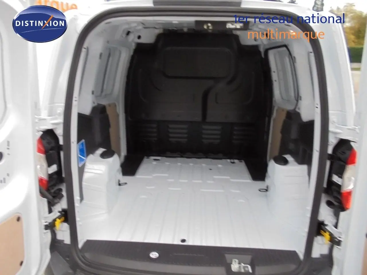 Vue arrière du Ford Transit Courier blanc glacier avec portes ouvertes montrant l'espace de chargement vide.