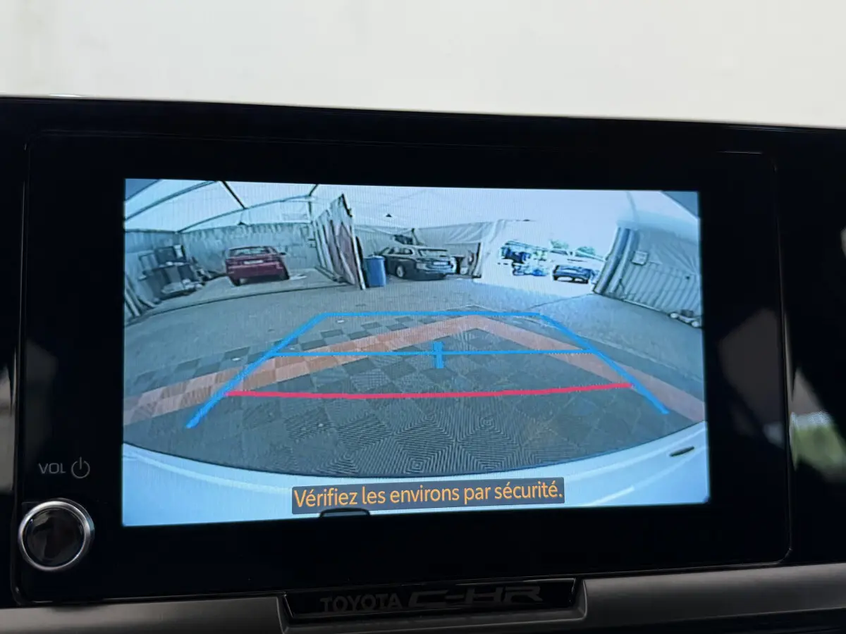 Affichage caméra de recul du Toyota C-HR blanc 2024 montrant l'arrière et les lignes de guidage colorées.