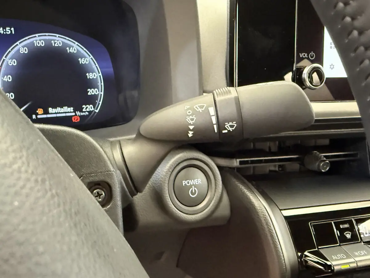 Gros plan sur le bouton Power et le commodo d'essuie-glace côté gauche du tableau de bord du Toyota C-HR blanc 2024.