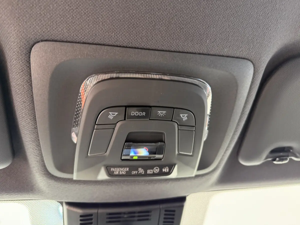 Vue en gros plan du plafonnier noir avec commandes d'éclairage et indicateur airbag du Toyota C-HR blanc 2024.