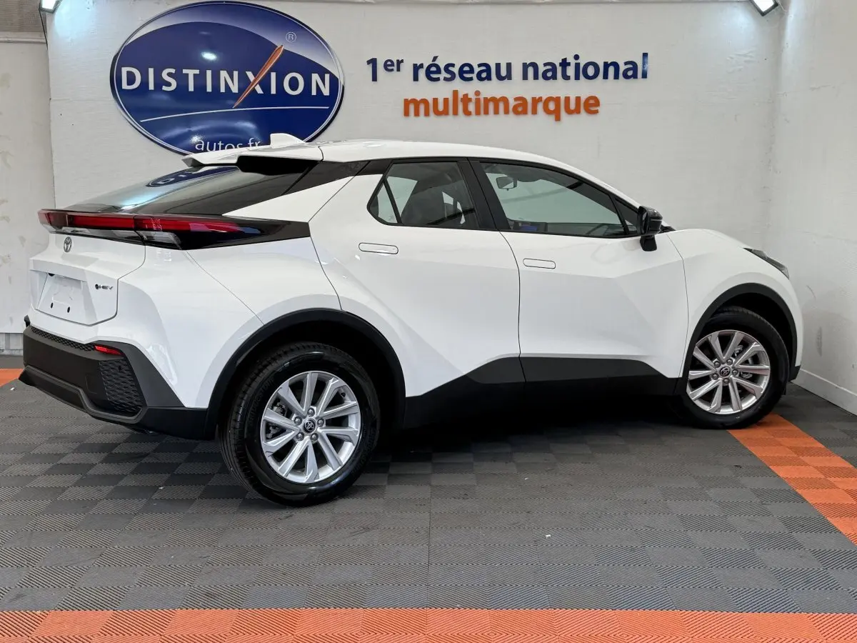 Toyota C-HR 1.8 Hybride blanc vu de profil côté gauche, avec jantes alliage et toit noir contrasté