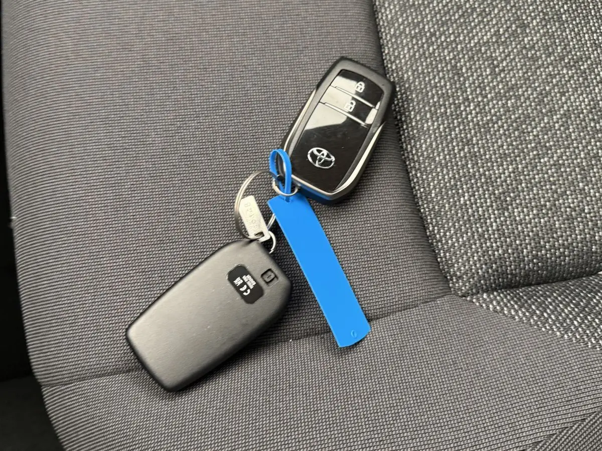 Clé Toyota noire posée sur siège tissu gris foncé à motifs, intérieur du Toyota C-HR 1.8 Hybride 140 Dynamic 2024.