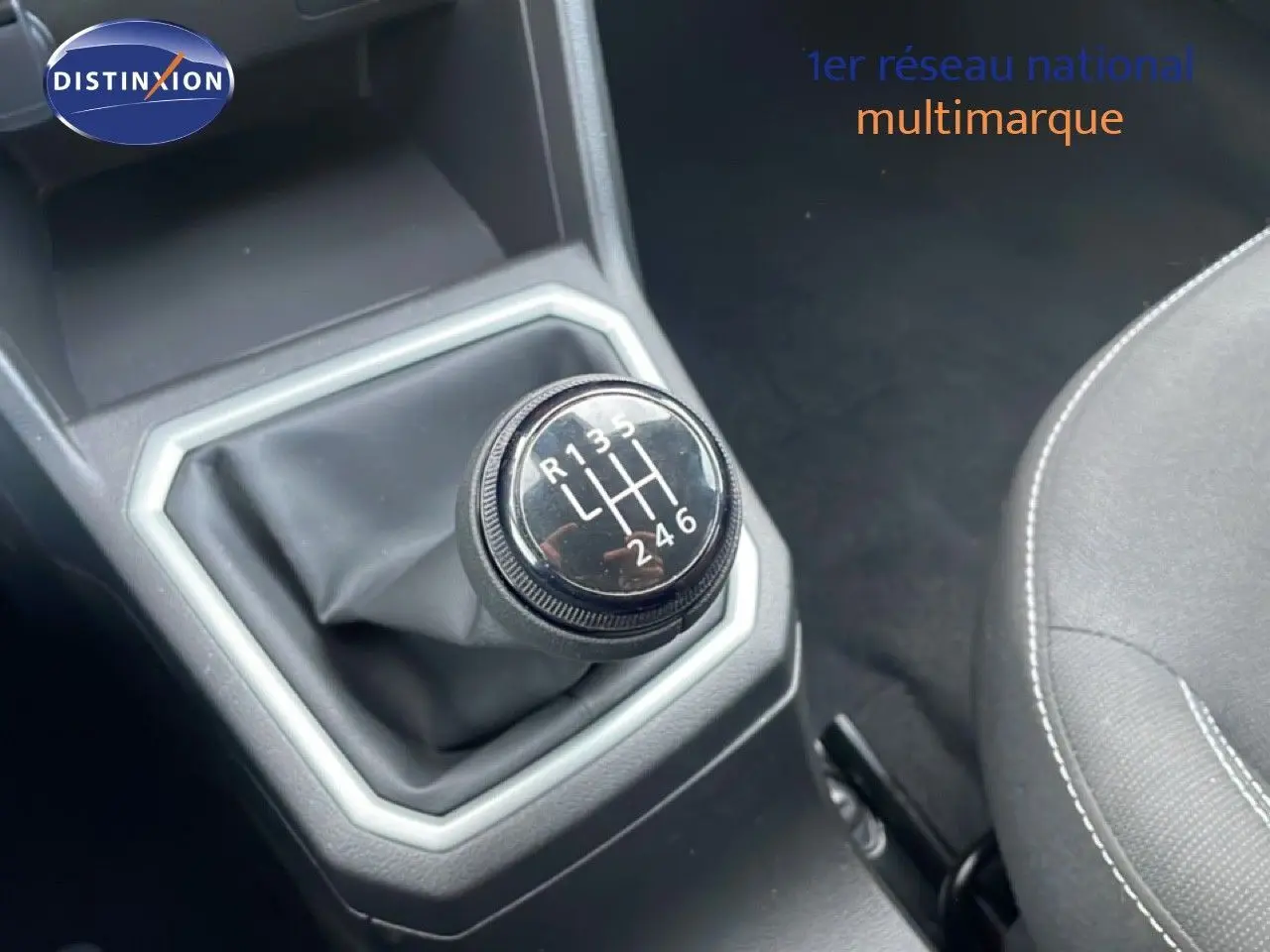 Gros plan sur le levier de vitesses manuel du Dacia Jogger gris schiste métal, avec coutures visibles sur le siège noir à côté.