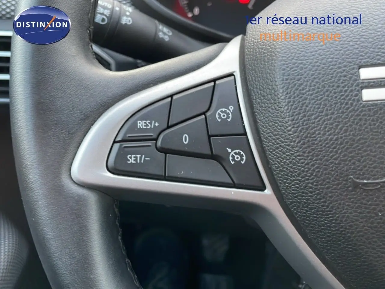 Gros plan sur les commandes au volant du Dacia Jogger 2025, cuir noir avec boutons de régulateur de vitesse.