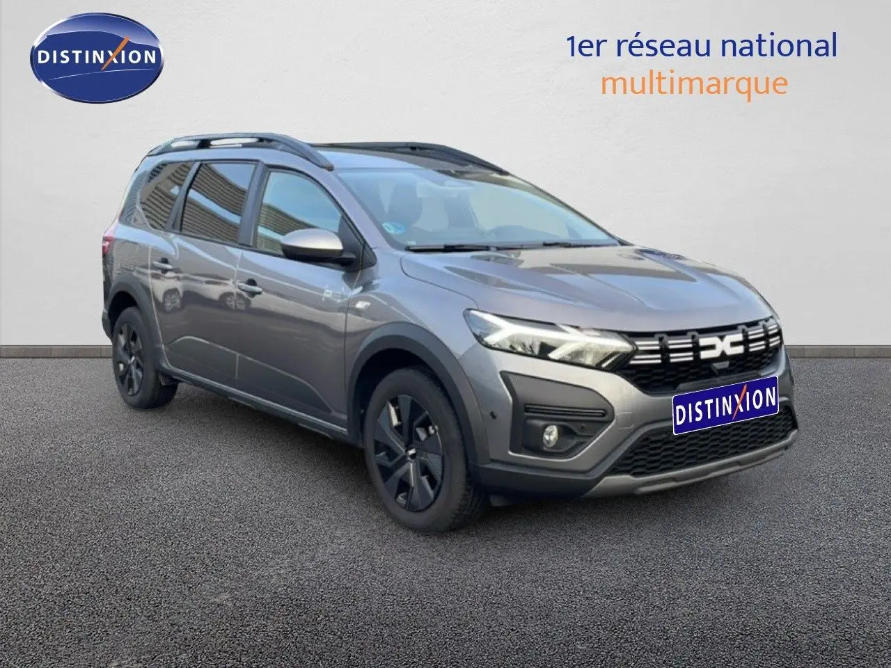 Dacia Jogger gris schiste métal en 3/4 avant droit, avec calandre noire et jantes foncées, sur fond neutre.