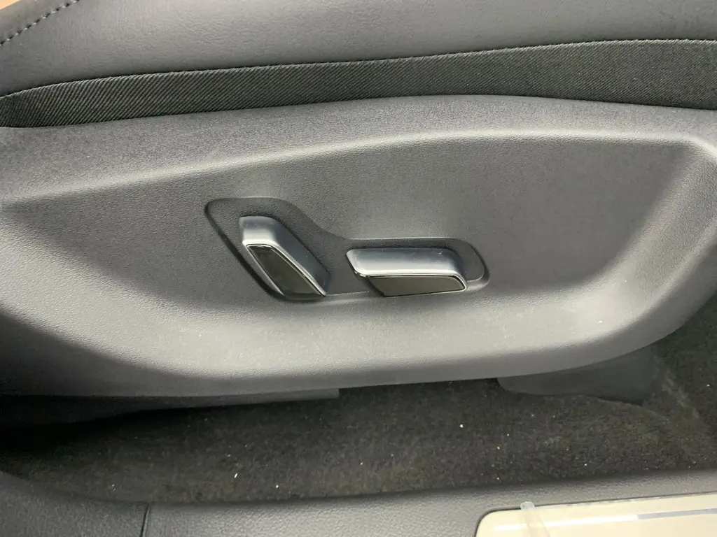 Gros plan sur les commandes électriques de réglage du siège conducteur du BYD SEAL U 2025 en intérieur noir.