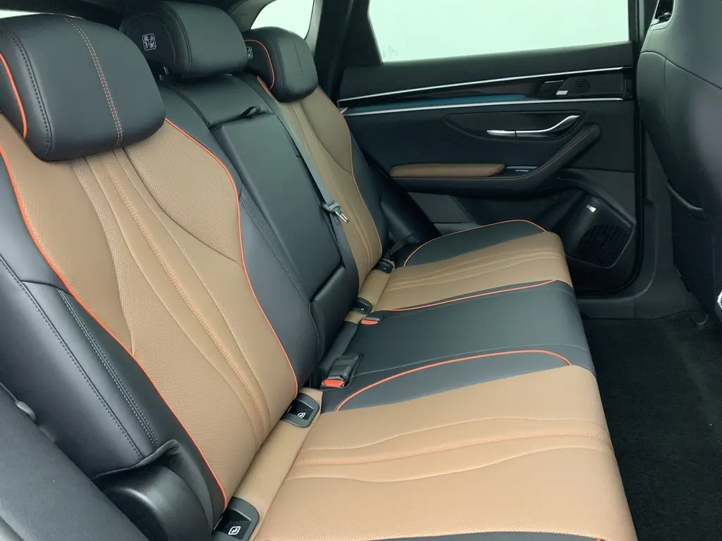 Vue latérale droite des sièges arrière bicolores noir et marron avec surpiqûres orange du BYD SEAL U 2025.
