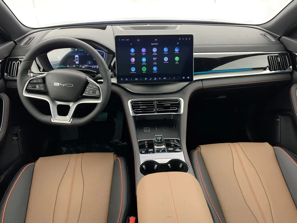 Vue intérieure avant du BYD SEAL U 2025 avec tableau de bord noir, écran tactile central et sièges cuir marron.