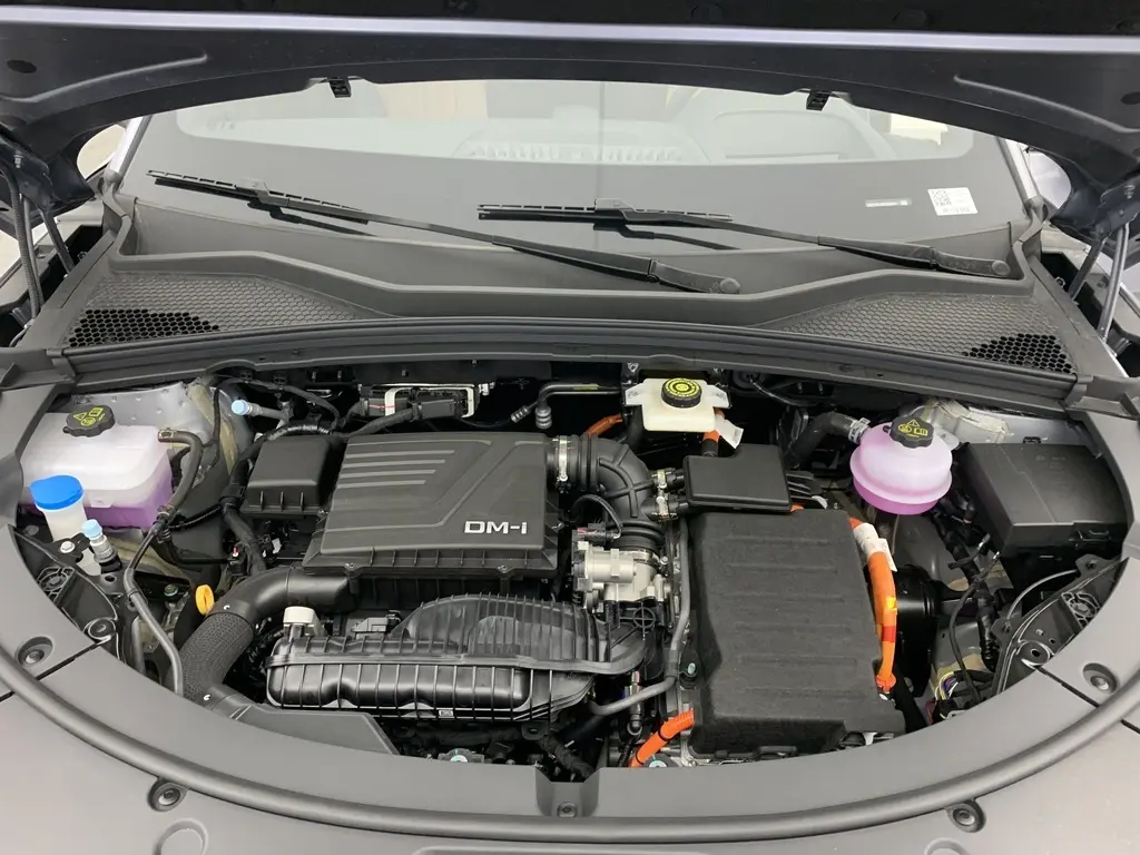 Vue rapprochée du compartiment moteur du BYD SEAL U 1.5l DM-i 218 ch PHEV Boost, avec capot ouvert et détails des composants.