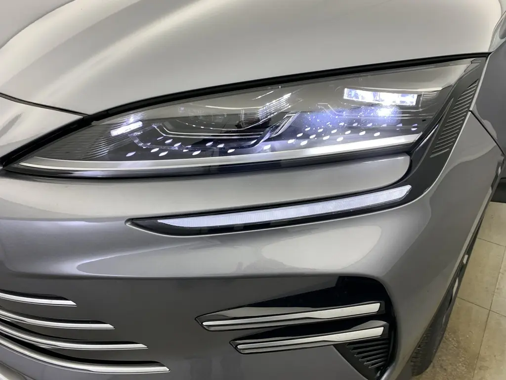 Gros plan sur le phare avant droit du BYD SEAL U Time Grey 2025 avec éclairage LED et détails chromés sur le pare-chocs.