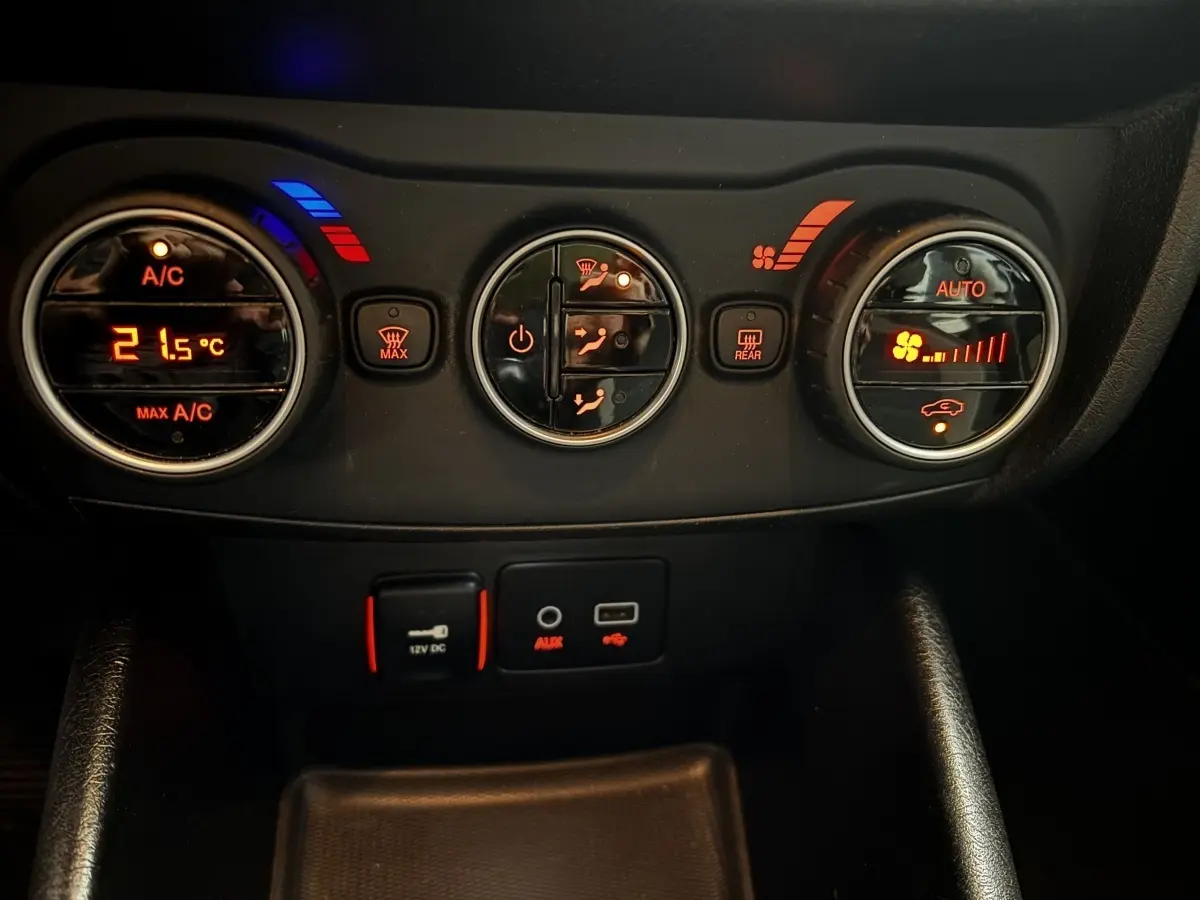 Vue rapprochée du tableau de bord noir du Fiat Tipo 2017, montrant les commandes de climatisation et prises USB/AUX.