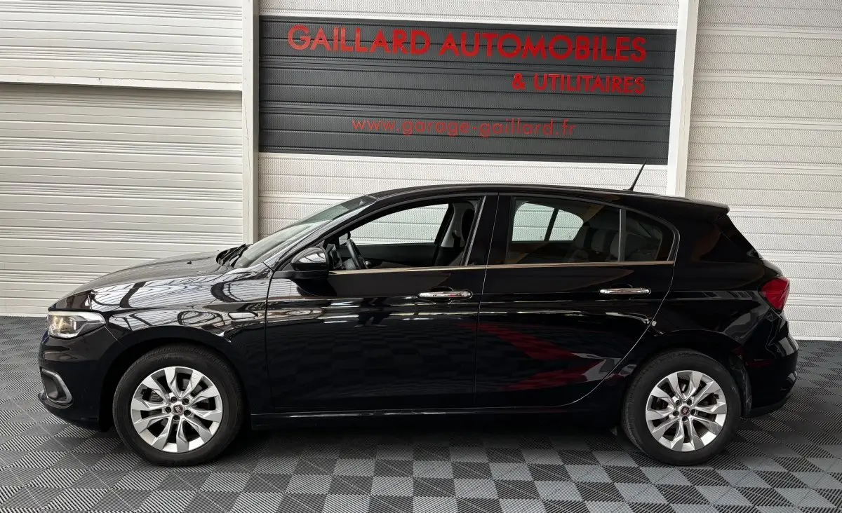 Profil latéral gauche d'une FIAT TIPO noire 2017, avec jantes alliage et poignées de porte chromées.