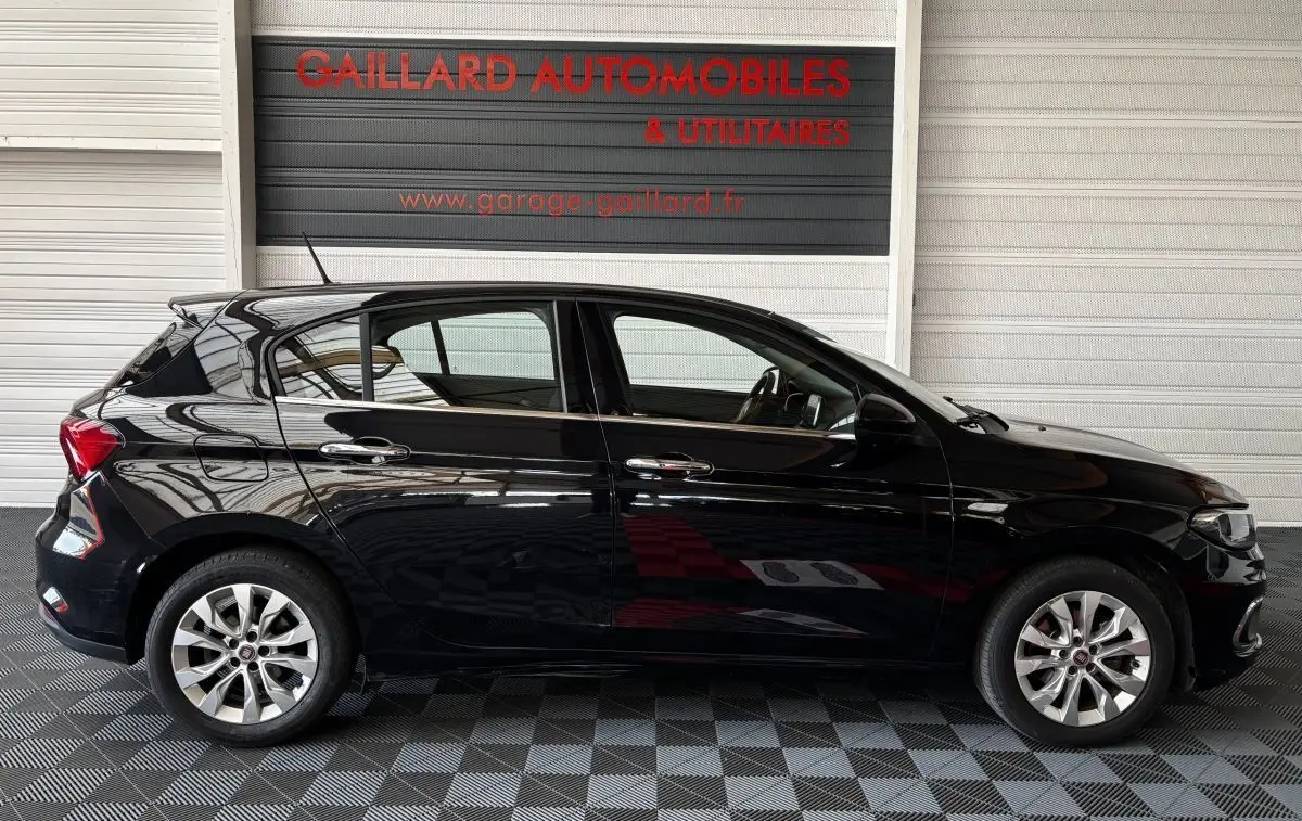Vue latérale droite d'une FIAT Tipo noire 2017, avec jantes alliage et poignées de porte chromées.