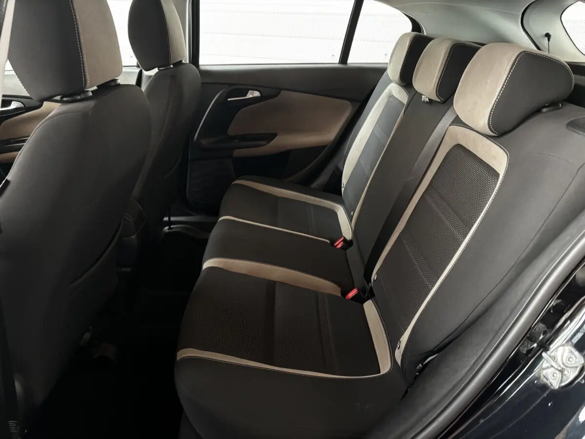 Vue intérieure côté droit des sièges arrière noirs et beige du Fiat Tipo 2017, avec garnitures en tissu et porte ouverte.