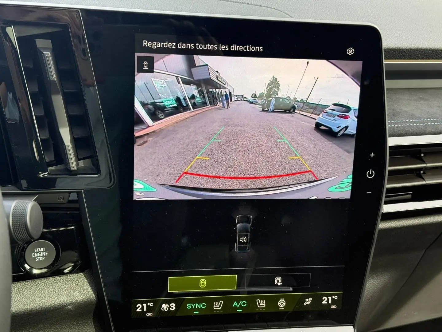 Écran tactile central du Renault Austral 2026 montrant la caméra de recul avec vue arrière sur parking extérieur.