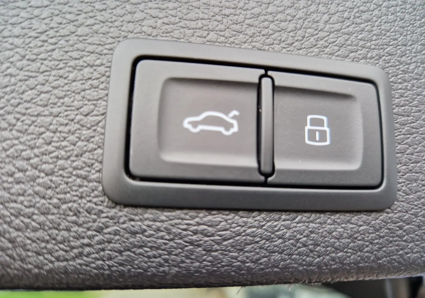 Gros plan sur les boutons d'ouverture du coffre et de verrouillage dans l'habitacle d'un Audi Q2 noir Mito Metal 2023