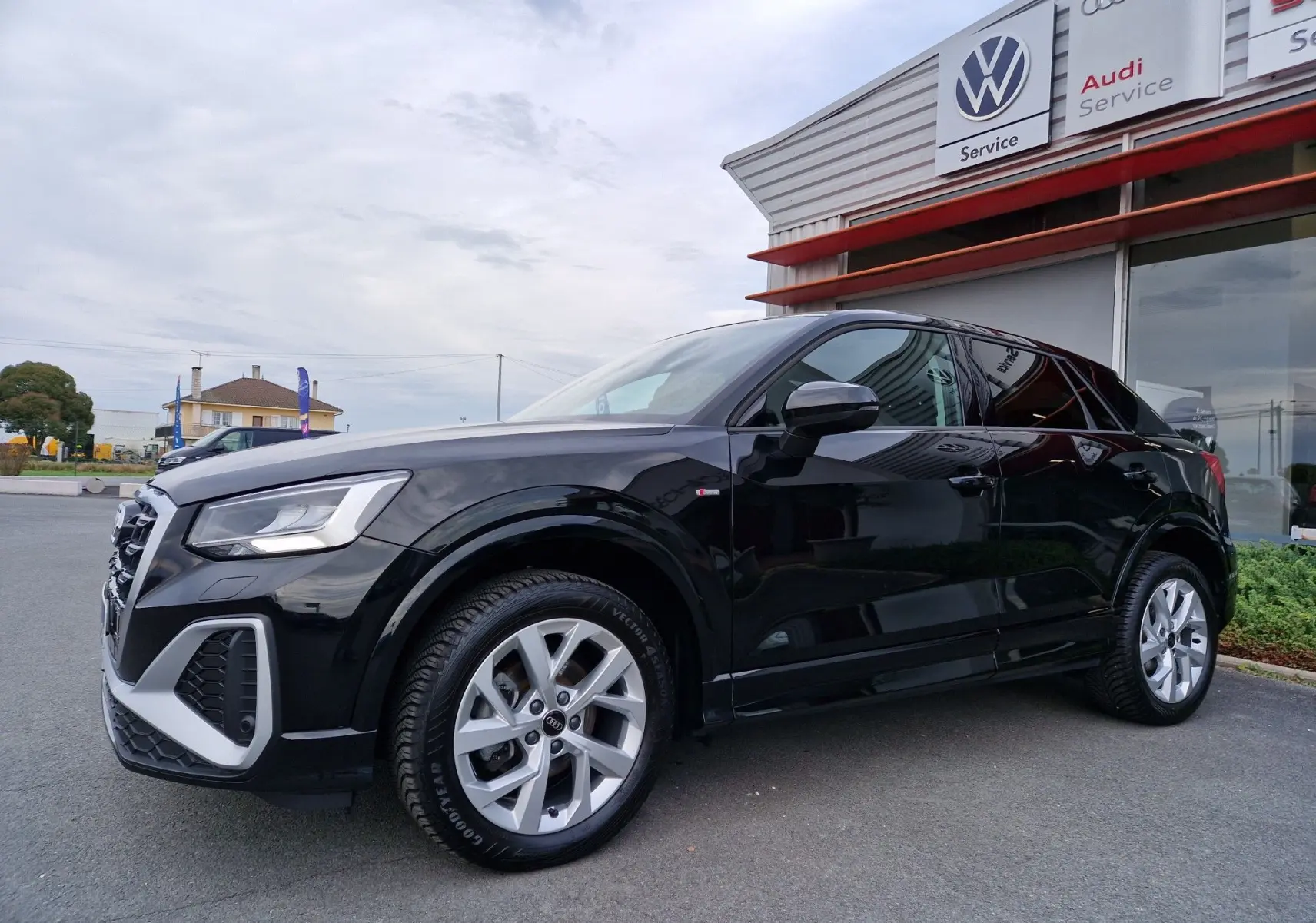 Audi Q2 noir mito metal vue 3/4 avant droit, mettant en valeur ses jantes alliage et son design compact urbain.