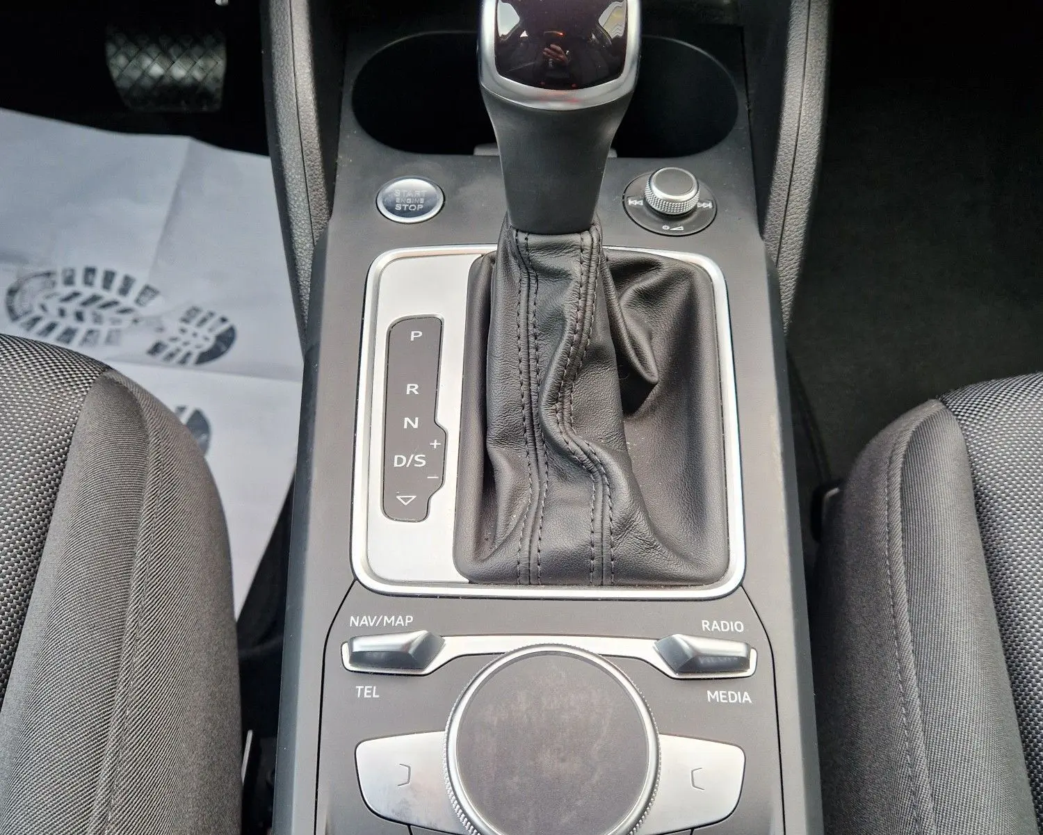 Gros plan sur la console centrale noire de l'Audi Q2 35 TFSI 2023 avec levier de vitesse automatique et commandes multimédia.