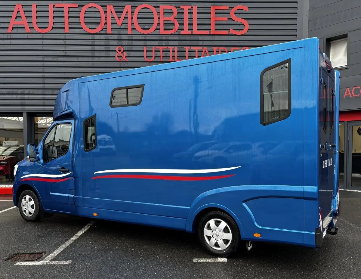 Vue latérale droite du Renault Master bleu 2020 avec fenêtres latérales et décor tricolore sur la carrosserie.