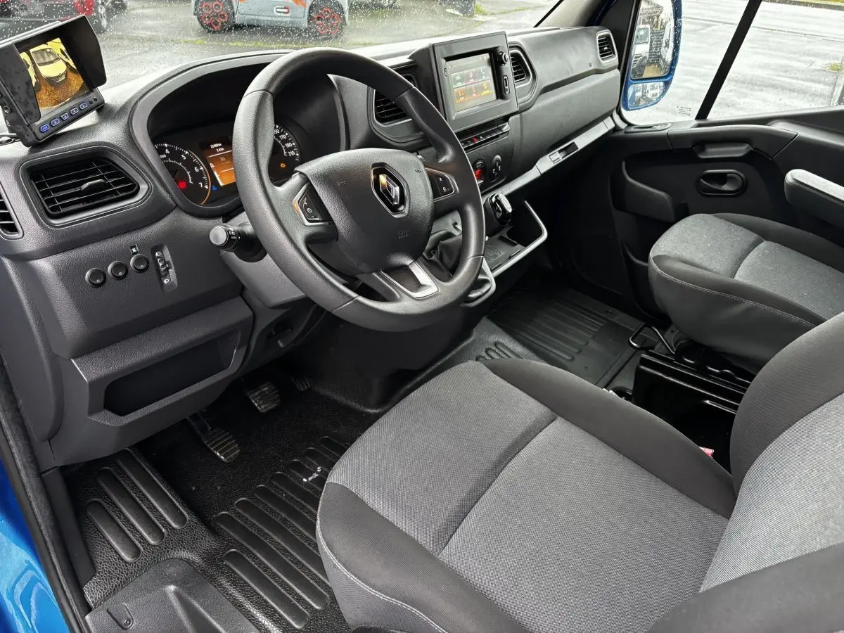 Vue intérieure côté conducteur du Renault Master 2020 bleu, montrant le volant, tableau de bord et écran central tactile.