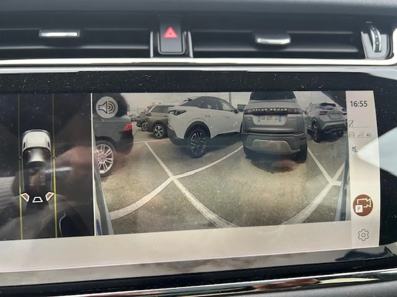 Vue écran caméra de recul montrant un Range Rover Evoque gris foncé de dos dans un parking.
