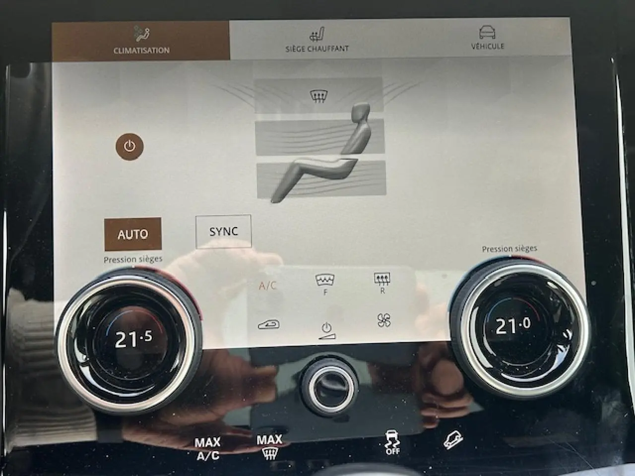 Écran tactile de la climatisation avec réglages sièges chauffants dans un Range Rover Evoque gris foncé, vue rapprochée.