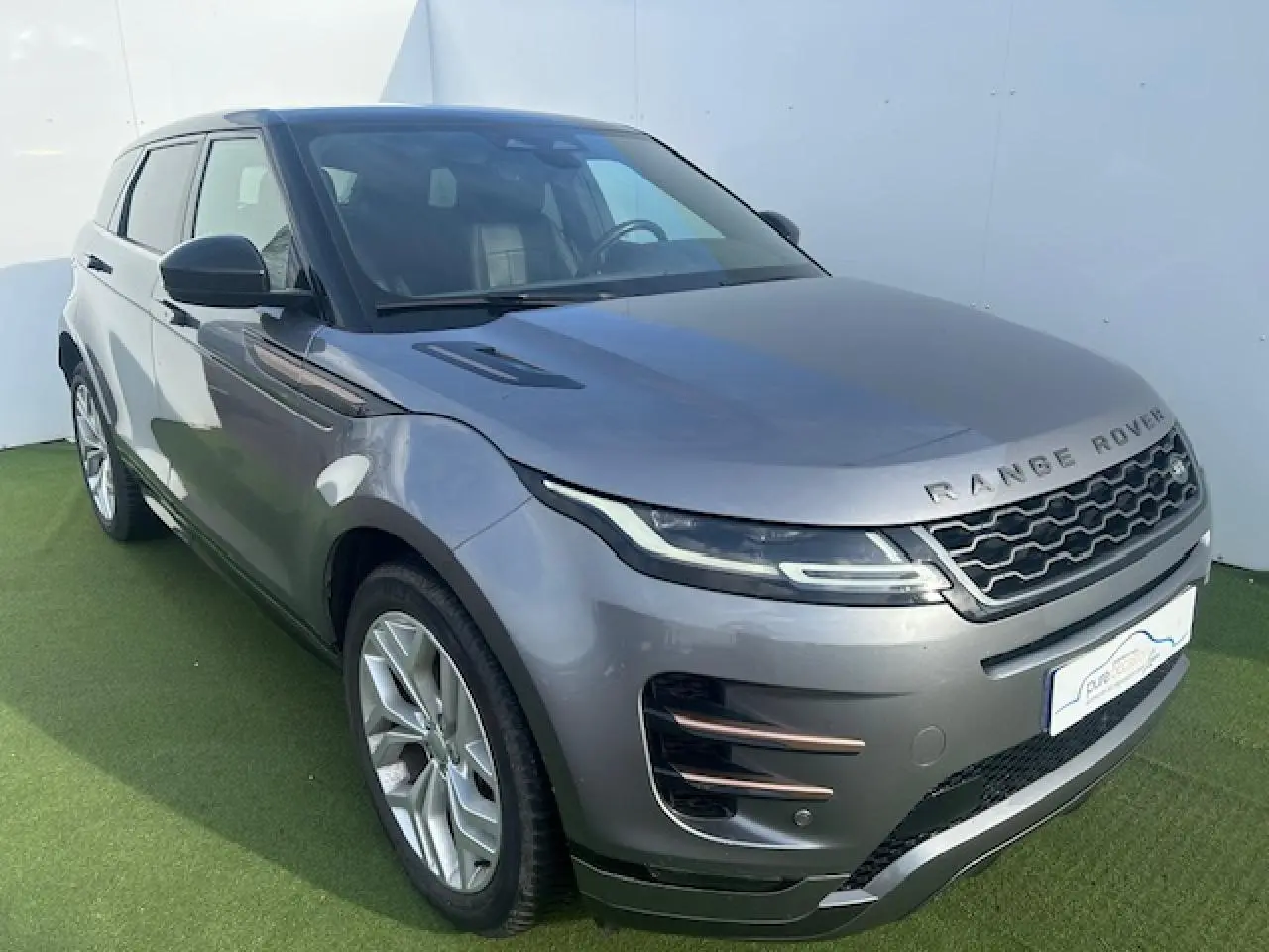 Range Rover Evoque gris foncé en 3/4 avant droit avec jantes 20 pouces et toit noir contrasté panoramique.