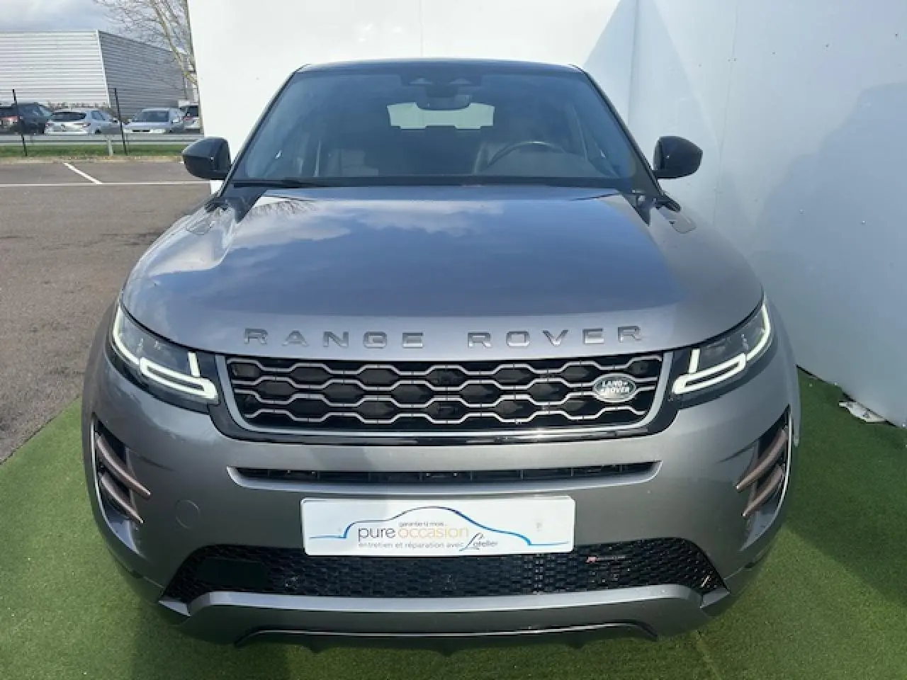 Vue avant d'un Range Rover Evoque II D200 4WD R-Dynamic SE gris foncé avec calandre hexagonale et phares LED distinctifs.