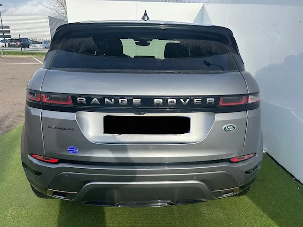 Vue arrière d'un Range Rover Evoque gris foncé avec toit noir et feux arrière LED horizontaux.