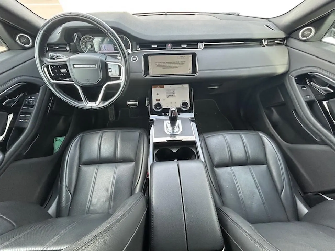 Vue intérieure avant du Range Rover Evoque II D200 4WD R-DYNAMIC SE 2022, sièges cuir noirs et tableau de bord moderne.