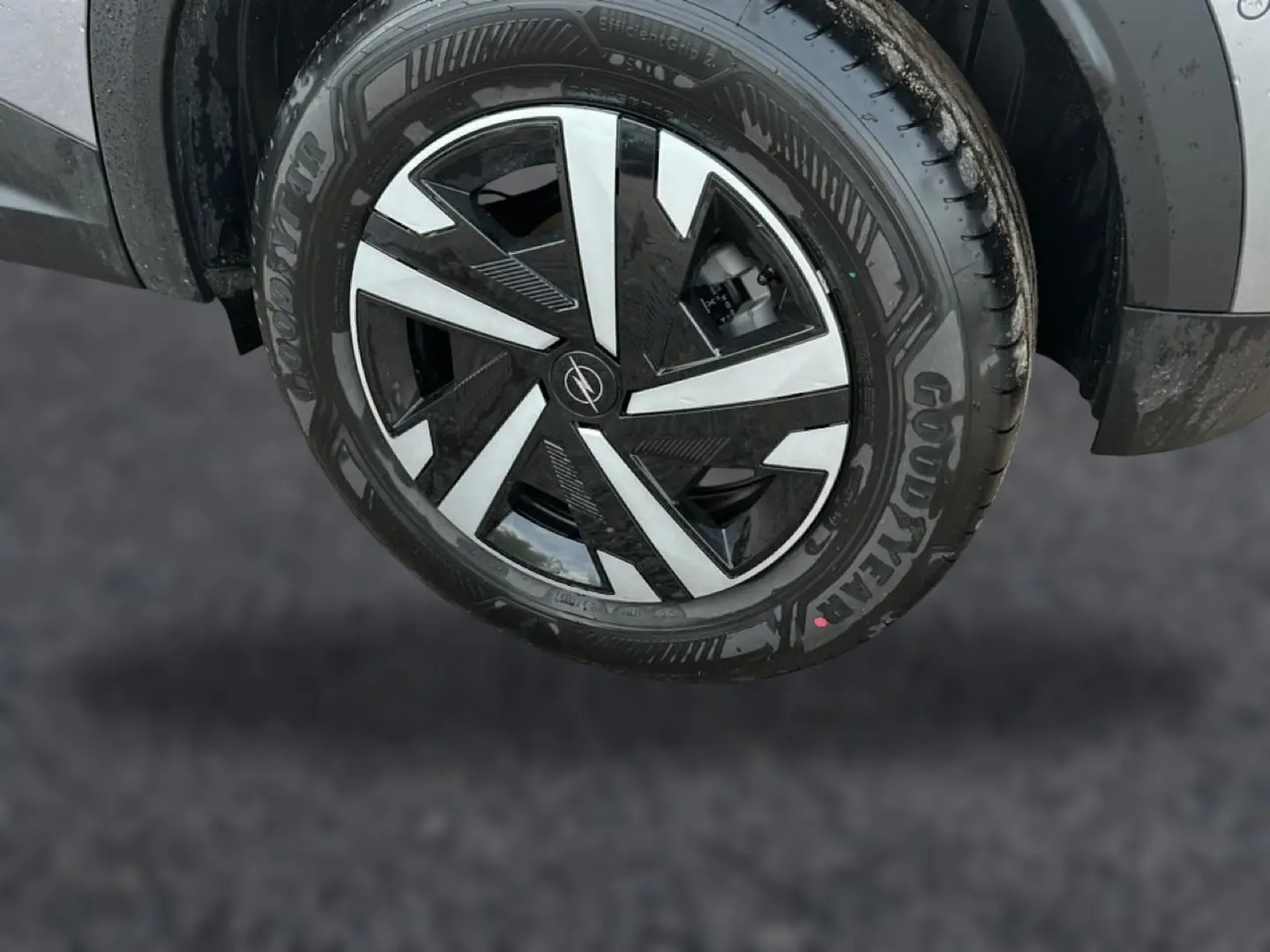 Gros plan sur la roue avant droite grise de l’Opel Mokka 2025 avec jante noire et argentée au design géométrique.