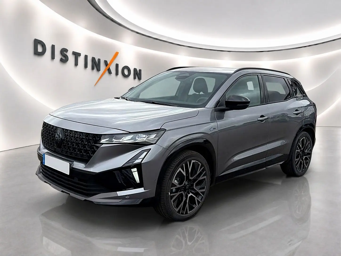 Renault Austral gris schiste en 3/4 avant droit, avec jantes alu noires et calandre noire distinctive.