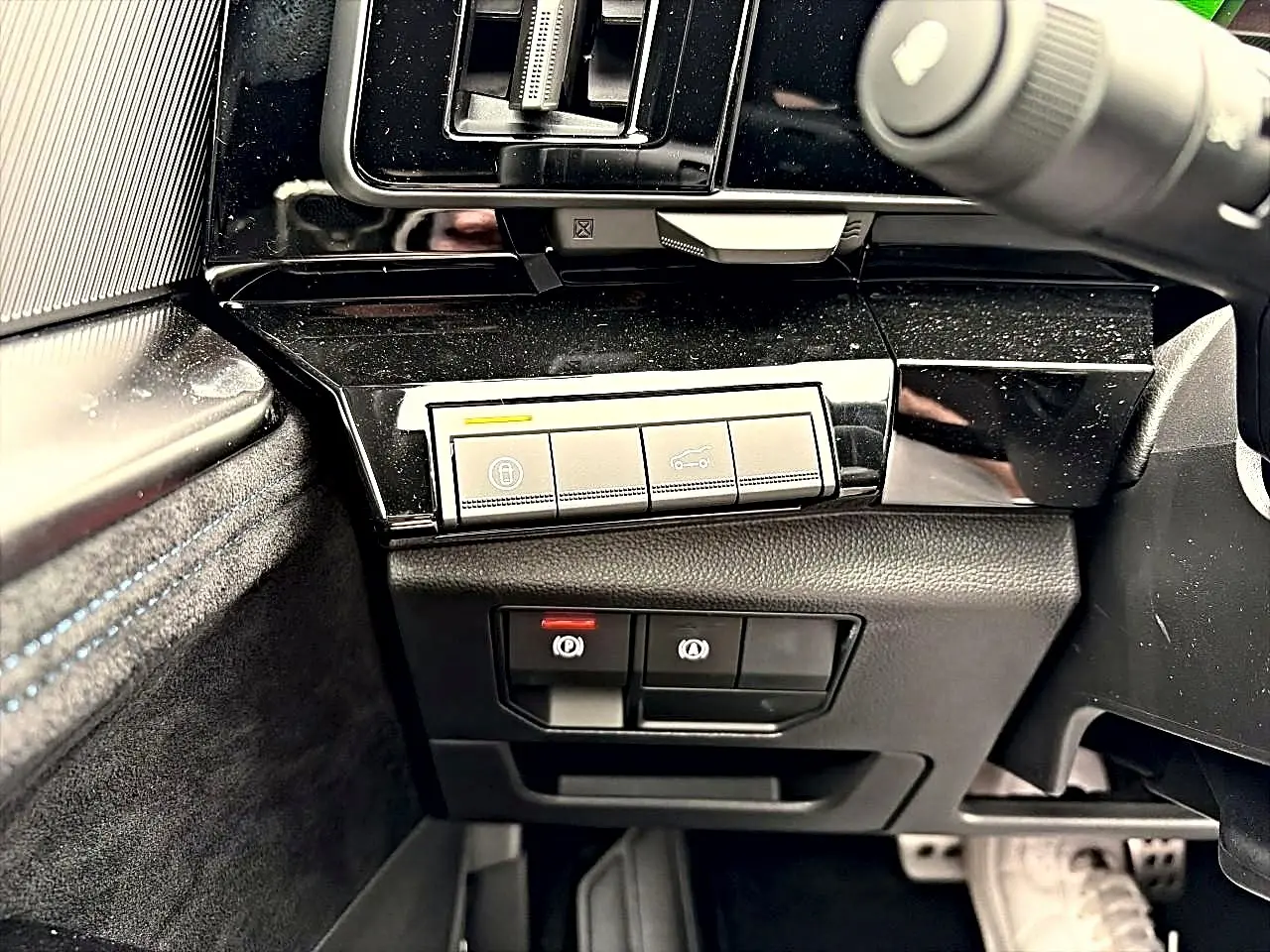 Détail intérieur côté gauche du tableau de bord noir brillant avec commandes de verrouillage et frein à main Renault Austral gris schiste.