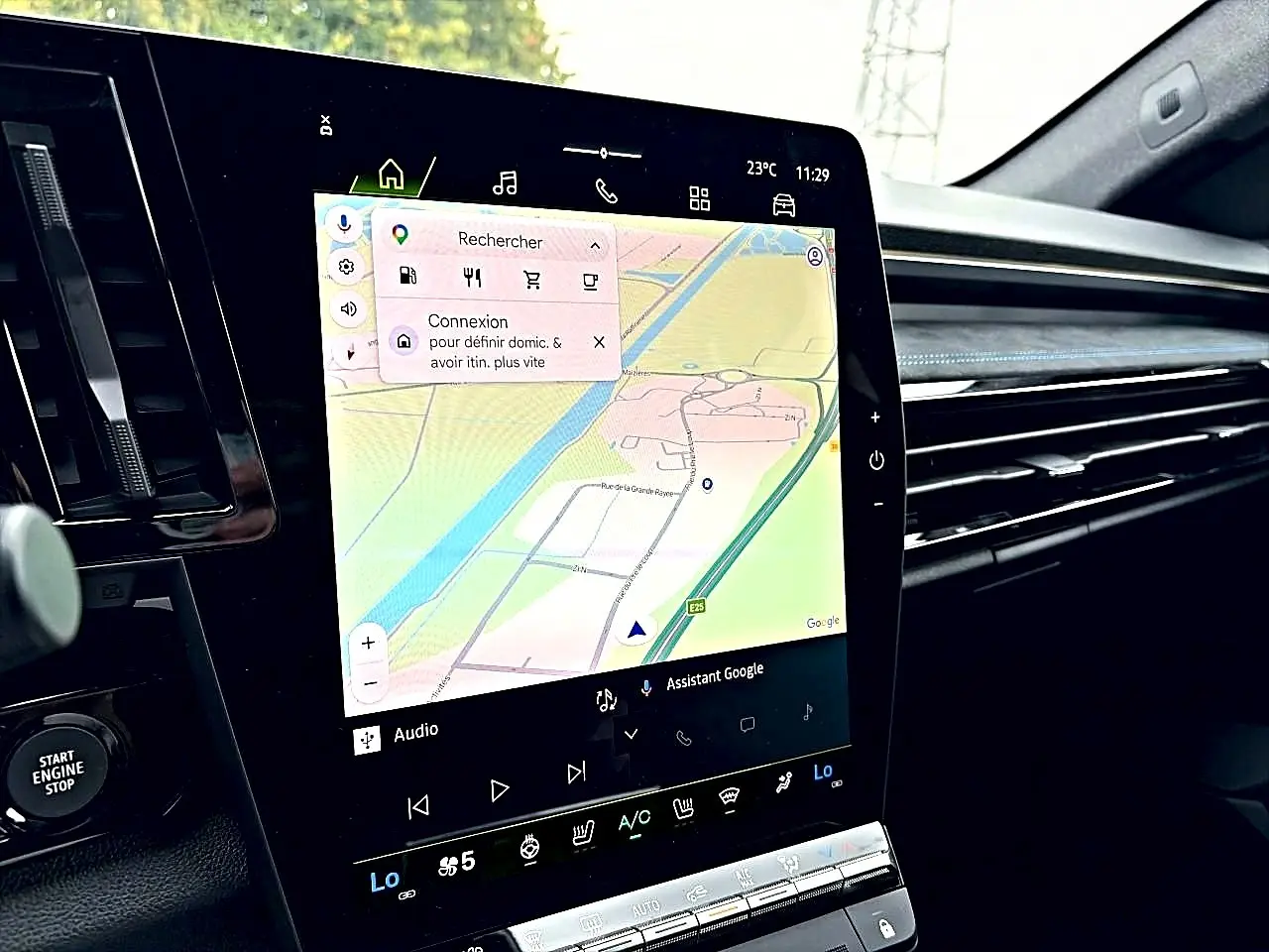 Vue intérieure du tableau de bord du Renault Austral gris schiste, avec écran tactile GPS et commandes climatisation visibles.
