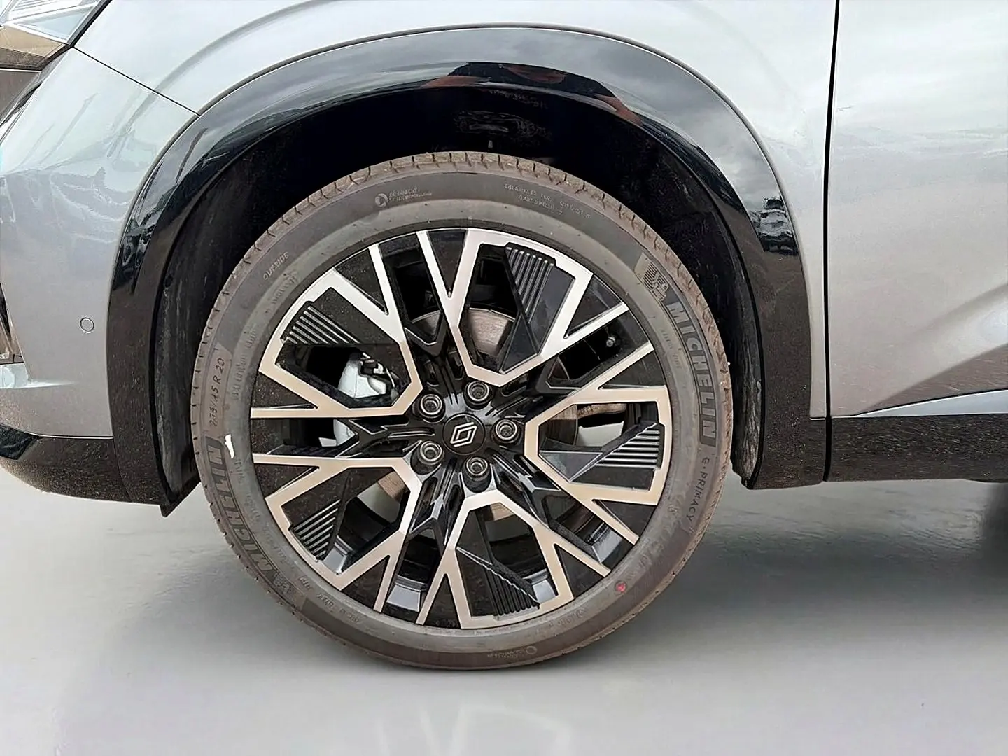 Gros plan sur la roue avant droite du Renault Austral gris schiste avec jante alu au design géométrique noir et argent.