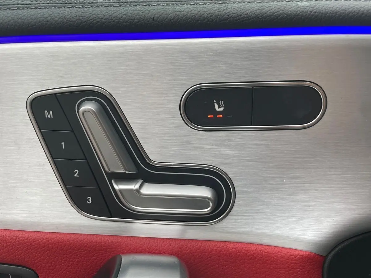 Détail des commandes de réglage de siège avec mémoire et chauffage sur la portière côté conducteur d'une Mercedes CLA Shooting Brake blanche 2021.