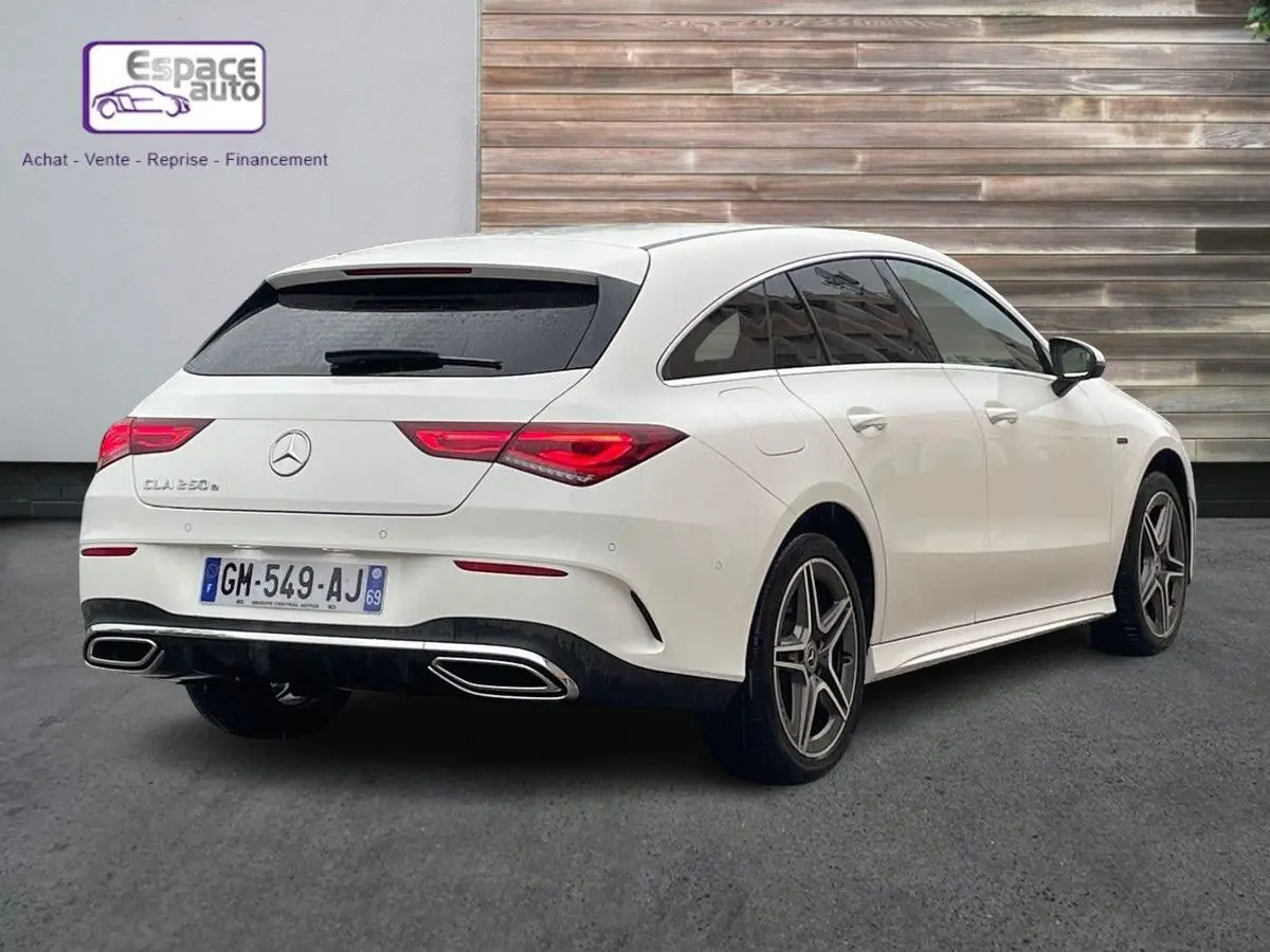Vue 3/4 arrière droite d'une Mercedes Classe CLA Shooting Brake blanche avec jantes AMG et feux arrière LED distinctifs.