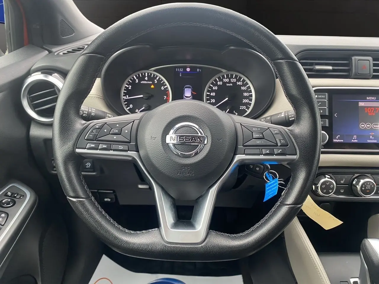 Vue rapprochée du volant noir de la Nissan Micra 2022 avec tableau de bord et écran central visible.