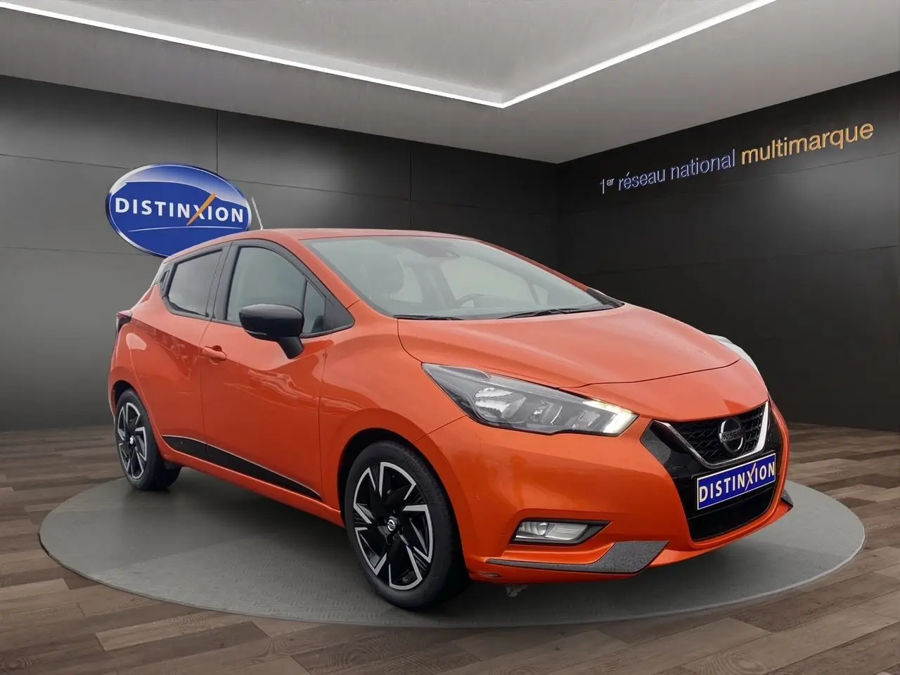 Vue 3/4 avant d'une Nissan Micra 2022 orange Energy avec jantes noires et détails noirs sur les rétroviseurs et bas de caisse.